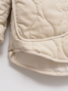 Detail of beige quilted jacket with onion stitching and high-quality edge binding