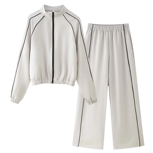 Détail d'un ensemble de sport gris clair deux pièces avec liserés noirs et veste zippée