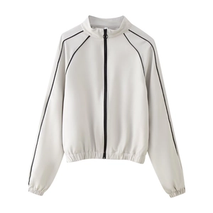 Détail d'une veste grise à col montant avec fermeture éclair noire et rayures latérales