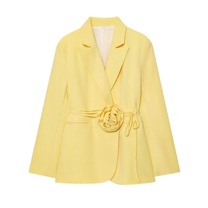 Détail d'un blazer jaune pâle orné d'une rose en relief sur la ceinture à nouer
