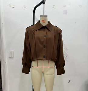 Detailed close-up of dark brown cropped jacket with button front and pleated puff sleeves