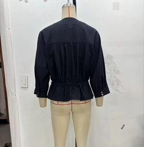 Detailed back view of black linen-blend jacket with elastic waist and gold button cuffs