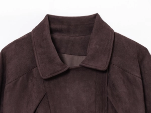 Detailaufnahme einer dunkelbraunen Wildlederjacke mit breitem Revers und feinen Nähten