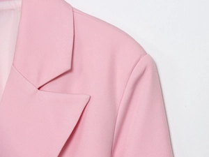 Détail de la veste rose avec revers en pointe et texture de tissu haut de gamme