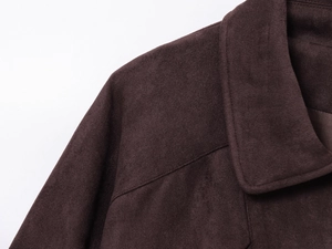 Detail einer dunkelbraunen Wildlederjacke mit Präzisionsnähten und flachem Reverskragen
