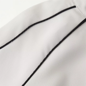Gros plan détaillé du tissu tissé gris clair avec un liseré contrasté noir net