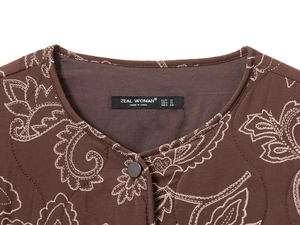 Détail du col rond et de la broderie matelassée paisley sur veste marron