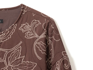 Détail d'une veste matelassée en coton marron foncé avec broderie de feuilles au col