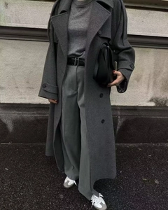 Detail shot of a grey wool coat with a black leather belt in a minimalist street style look