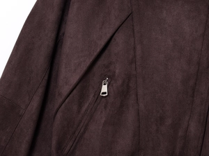 Makroaufnahme einer dunkelbraunen Wildlederjacke mit Reißverschluss und Revers
