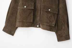 Detail of dark brown suede bomber jacket featuring large utility pockets and silver snaps