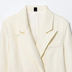 Elegant ivory double-breasted long blazer with peak lapels and premium twill texture