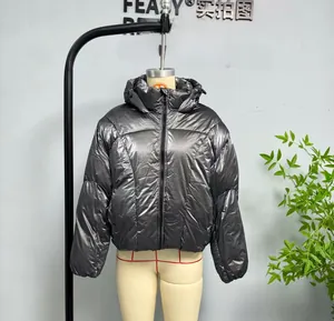 Detail of metallic silver puffer jacket featuring hooded design and black zipper closure