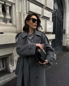 Detail view of premium dark grey wool coat texture and modern minimalist urban outfit