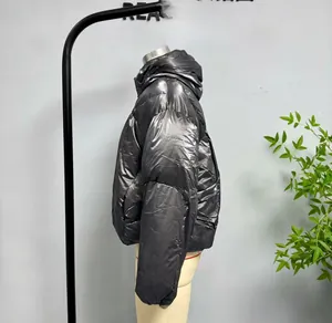 Close-up of shiny dark grey metallic puffer jacket with reflective texture and hood