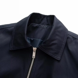 Detail of the navy jacket collar with premium stitching and silver metal zipper