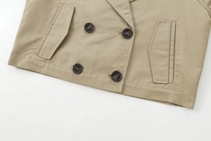 Detail of khaki jacket with double-breasted black buttons and flap pockets