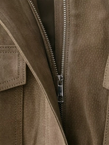 Macro shot of silver metal zipper and brown suede texture on a vintage jacket