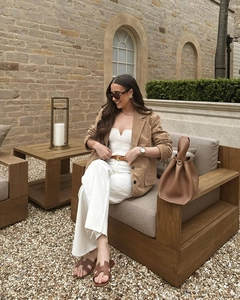 Detail showing high-quality brown faux suede jacket paired with white wide-leg trousers