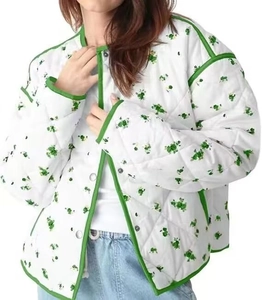 Detailed close-up of quilted cotton floral jacket with green piping and metal snap buttons
