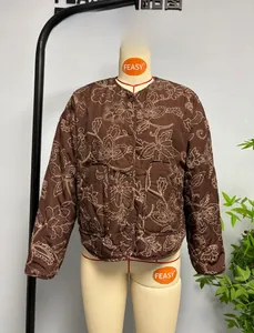 Detail of brown quilted jacket with floral paisley embroidery and button closure