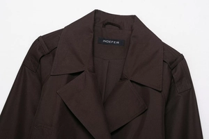 Close-up detail of dark brown trench jacket with lapels and stitched epaulettes
