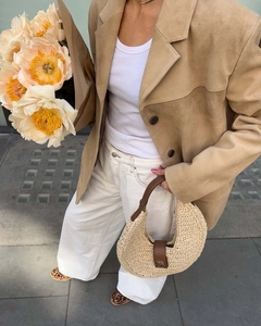 Street style shot of a camel faux suede oversized blazer styled with a straw handbag