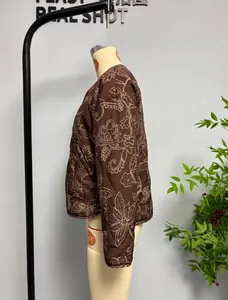 Detailed embroidery view of a brown quilted floral jacket with vintage pastoral style