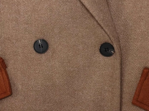 Close-up of premium camel wool coat with precise stitching and stylish resin buttons