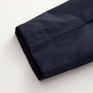 Close-up of navy twill fabric showing double-needle stitching on jacket sleeve cuff