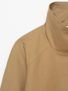 Close-up of khaki jacket collar and raglan sleeves with premium stitching detail
