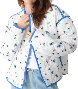 Detail view of the quilted floral jacket featuring blue contrast piping and metal snap buttons