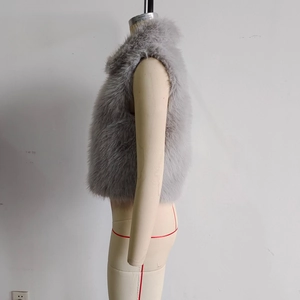 Detail view of the plush grey faux fur vest texture on a clothing mannequin