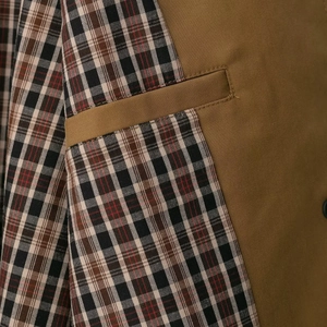 Khaki trench coat featuring stylish plaid patchwork details and a precise welt pocket