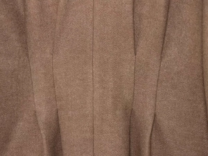Macro view of brown wool fabric texture with detailed vertical stitching on jacket