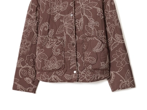 Détail de la veste matelassée marron foncé avec broderies florales blanches et poches
