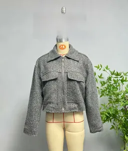 Close-up of grey textured tweed jacket with zip closure and utility pockets