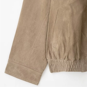 Front view of a light brown faux suede jacket with ribbed hem and pocket details