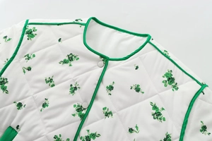 Detail of green floral quilted cotton jacket with silver snap buttons and round neck