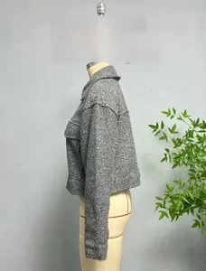 Detail of grey tweed cropped jacket with large flap pockets and textured fabric