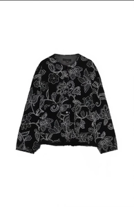 Detail of floral embroidery on black round neck cotton jacket with large pockets