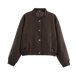 Détail d'une veste courte en tweed marron foncé avec boutons-pression argentés et poches