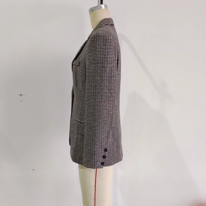 Detail of classic houndstooth blazer showing high-quality tweed fabric and cuff buttons