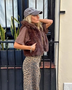 Street style shot of brown faux fur vest layered over t-shirt with leopard pants