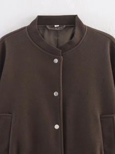 Détails d'une veste en tweed marron foncé avec boutons métalliques et col côtelé