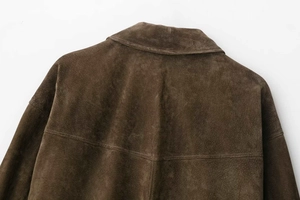 Détail de la couture arrière et de la texture en daim d'un blouson aviateur marron