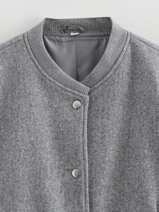 Détail du bomber en tweed gris avec col côtelé et boutons-pression en métal argenté