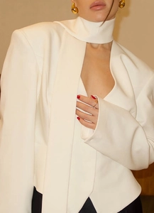 Detail of white V-neck blazer with unique scarf collar design and padded shoulders