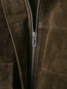 Vue macro du zip métallique argenté et texture suédée marron sur la veste pilote