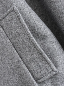 Gros plan sur le tissu en tweed gris chiné avec coutures précises sur une veste